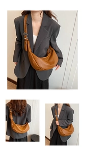 Detail of a brown PU leather crescent bag with adjustable wide strap and silver metal buckle