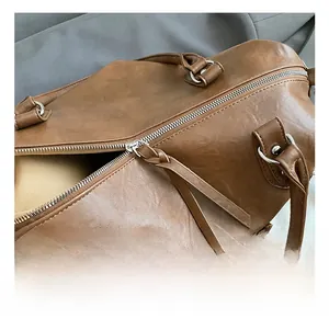 Detail view of large brown PU leather tote with silver metal hardware and smooth zipper