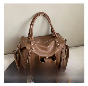 Close-up of brown PU leather texture and silver zipper pockets on a large tote bag