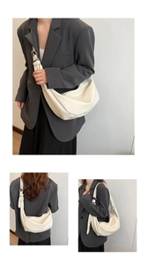 Detail of off-white dumpling bag with textured leather and large silver metal buckle