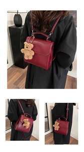 Detail of burgundy vintage backpack with matte leather texture and cute bear charm