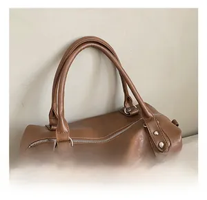Detail view of double handles and silver rivet accents on brown vintage PU leather bag