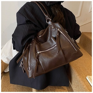 Detail of dark brown PU leather tote with silver zippers and long fringe tassels