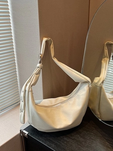 Cream hobo bag in oil wax leather style with knotted shoulder strap and crescent design