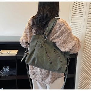Olive green vintage tote bag with zip pockets shown in a lifestyle indoor setting