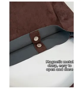 Detail of the high-quality silver magnetic buckle on a vintage dark brown suede tote bag