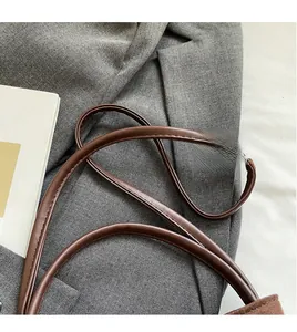 Vue détaillée d'une bandoulière en cuir marron avec coutures fines sur un sac à main