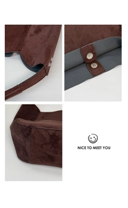 Detail view of dark coffee suede tote bag with magnetic closure and premium stitching