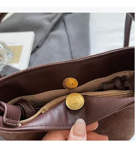 Détail du sac seau marron mat avec fermoir magnétique doré et doublure intérieure beige