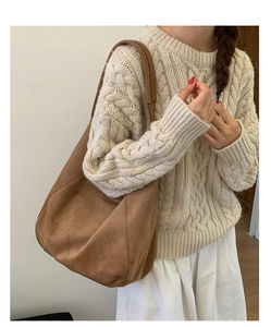 Brown suede slouchy tote bag shown on model wearing a beige knitted sweater