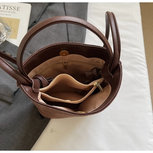 Vue détaillée de l'intérieur du sac seau en daim marron avec plusieurs compartiments