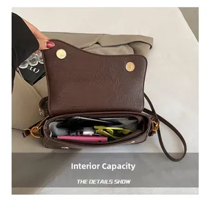 Vue détaillée de l'intérieur d'un sac besace rétro montrant poches et doublure géométrique