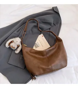 Detail of vintage brown textured hobo tote bag with a cute white plush bunny charm