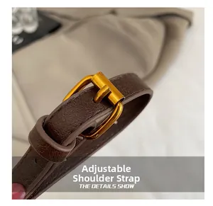 Détail de la bandoulière réglable en cuir marron foncé avec boucle dorée mate