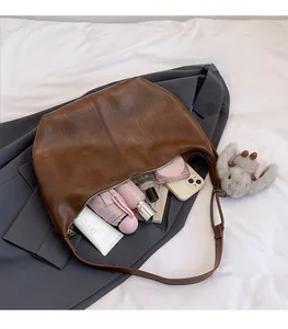 Macro shot of large brown leather tote interior showing space for umbrella and phone