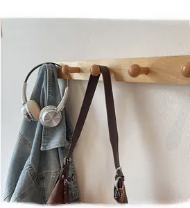 Detail of wall-mounted solid wood coat rack with four spherical hooks and natural texture
