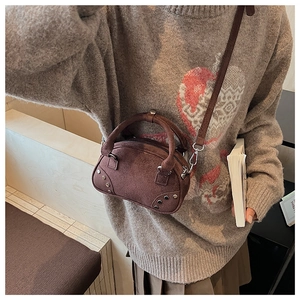 Deep brown suede mini boston bag with silver rivets shown on model in autumn outfit