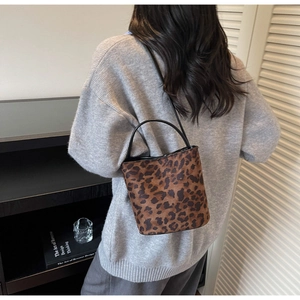 Vue arrière d'un mannequin portant le sac seau léopard en simili poil de poulain