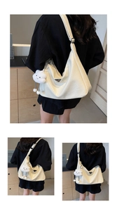 Détail du sac Hobo crème en cuir texturé avec logo en métal et breloque nuage doux