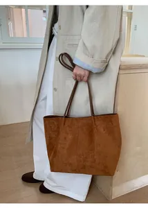 Close-up of a brown suede tote bag with slim leather handles for casual daily styling