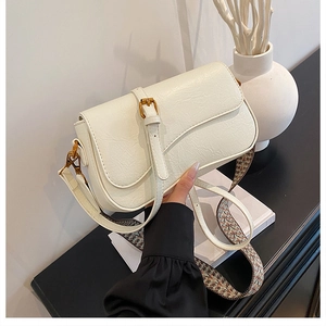 Détail du sac crème en cuir PU texturé avec bandoulière ethnique tissée