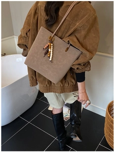 Dettaglio borsa shopper marrone con nappa bohémien in perline di legno colorate