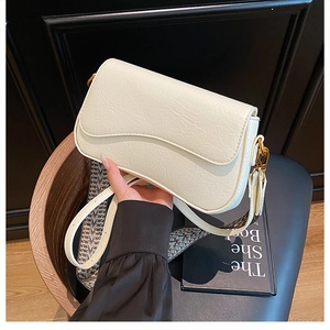 Détail du sac bandoulière blanc crème en cuir texturé avec sangle tissée et boucle dorée