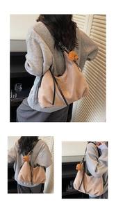 Detail of suede shoulder bag with black leather straps and a plush bear pendant