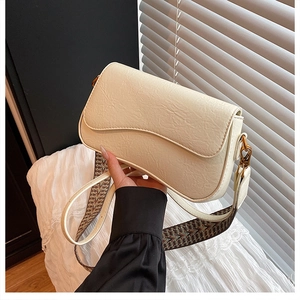 Détail du sac en cuir crème avec bandoulière tissée ethnique et finitions dorées