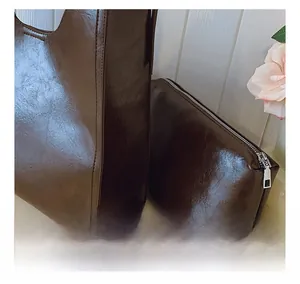 Détail du sac cabas marron foncé à texture lisse avec sa pochette zippée assortie