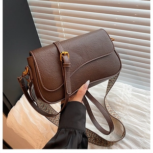 Détail du sac à bandoulière rétro marron foncé en cuir avec bandoulière tissée chic