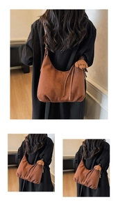 Close-up of a brown matte suede Hobo bag with a teddy dog pendant on the side