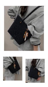 Dettaglio della borsa tote in pelle scamosciata nera con nappa etnica e tracolla fine
