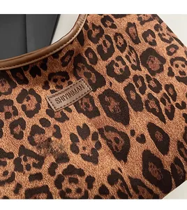 Detailed shot of leopard print tote bag with plush fabric and brown leather brand label