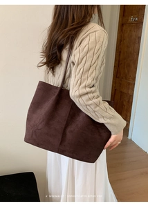 Detail view of large dark brown suede tote bag with retro vertical stitching details