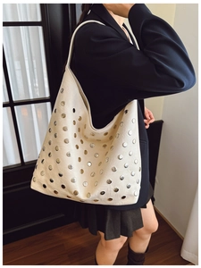 Détail d'un sac hobo beige avec rivets métalliques et texture de cuir PU de haute qualité