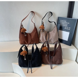 Macro view of four suede crescent shoulder bags in brown, beige, black, and coffee colors