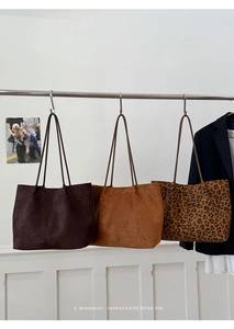 Detailed view of large leopard print and suede tote bags in minimalist retro style