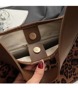 Detail of magnetic buckle and zipper pocket inside leopard print tote bag