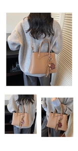 Close-up of brown pebbled leather tote bag with stylish leopard bear charm and fringe