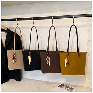 Dettaglio di borse tote vintage in beige, nero, marrone e giallo con nappe di perline colorate