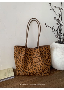 Detailed view of leopard print tote bag with brown straps in a retro minimalist setting