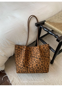 Detailed view of leopard print tote bag with brown straps in a retro minimalist setting