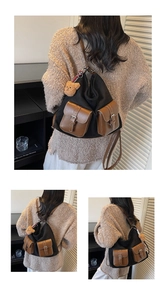 Close-up of contrast retro tote bag featuring brown leather pockets and a cute bear charm