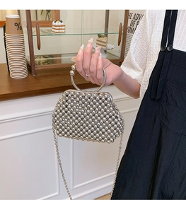 Detail of silver handmade beaded handbag with metal ring handle and crossbody chain