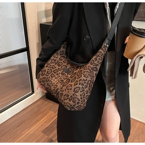 Dettaglio borsa hobo leopardata con tracolla in pelle nera e applicazione logo frontale