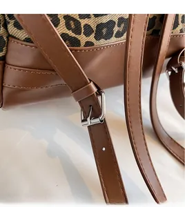 Detail eines verstellbaren braunen Ledergurts mit Silberschnalle an einer Leoparden-Tasche