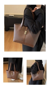 Close-up of brown pebbled leather tote bag with elegant gold twist lock and shoulder straps