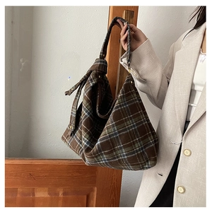 Detail of vintage wool tote bag featuring brown grid weave and thick knotted shoulder strap