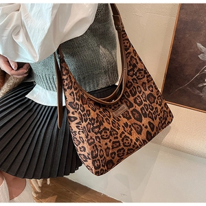 Dettaglio della borsa tote leopardata con tracolla in pelle e toppa con logo